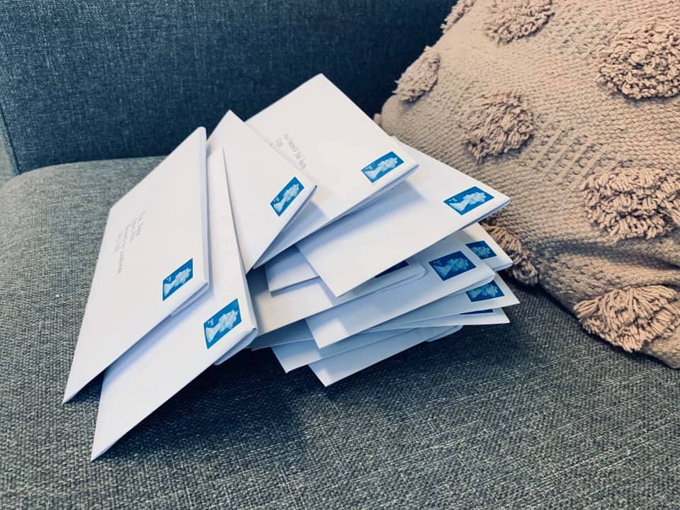 A stack of envelopes casually placed on a couch.