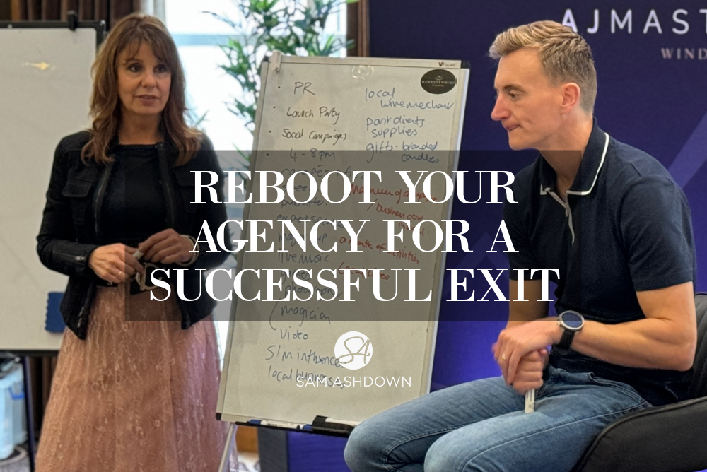 A woman and man discuss strategies in a business workshop. A whiteboard behind them shows PR and social campaign notes. Text overlay reads: "Reboot Your Agency for a Successful Exit."